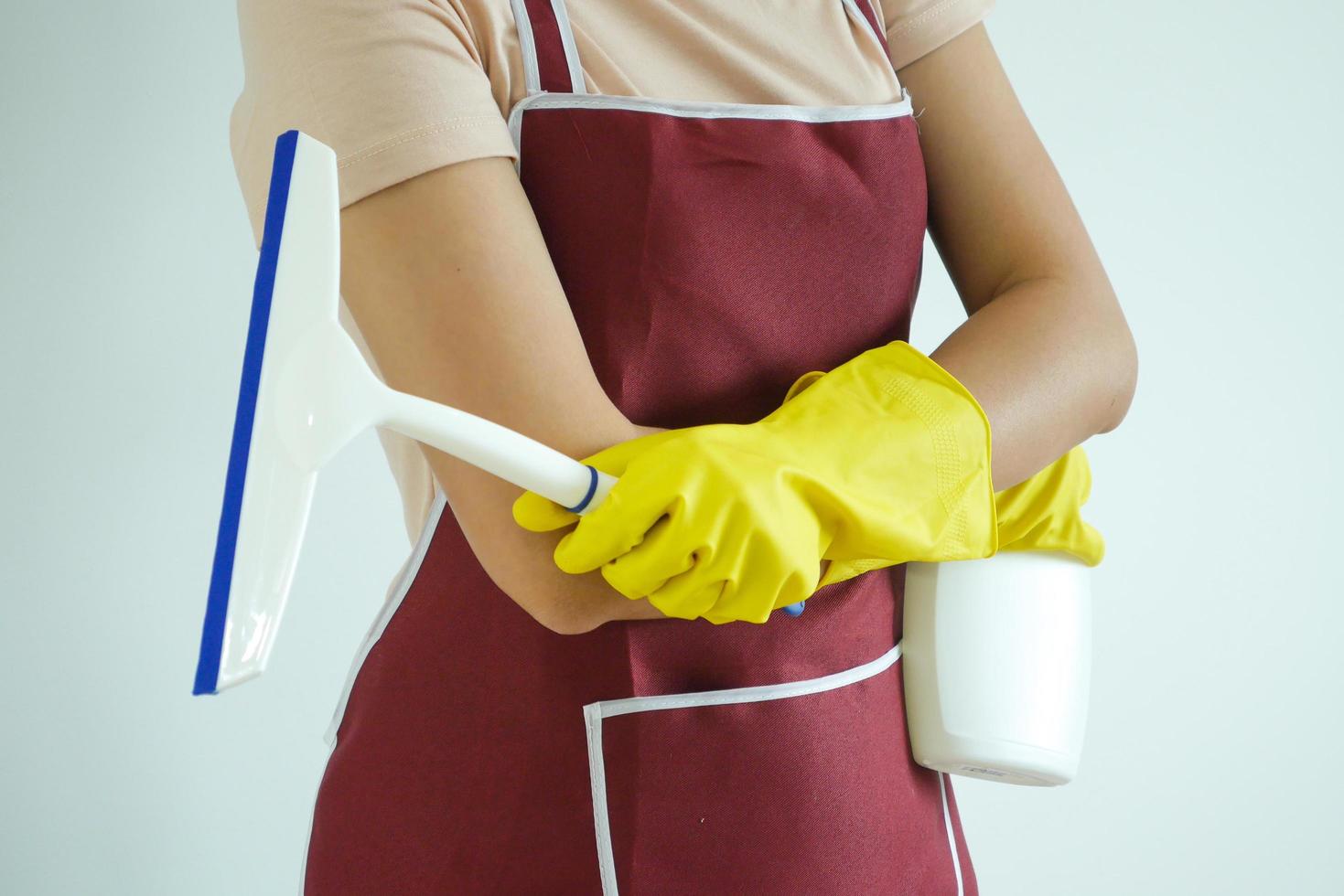 mujer que lleva casa limpieza equipo por vistiendo caucho guantes. foto