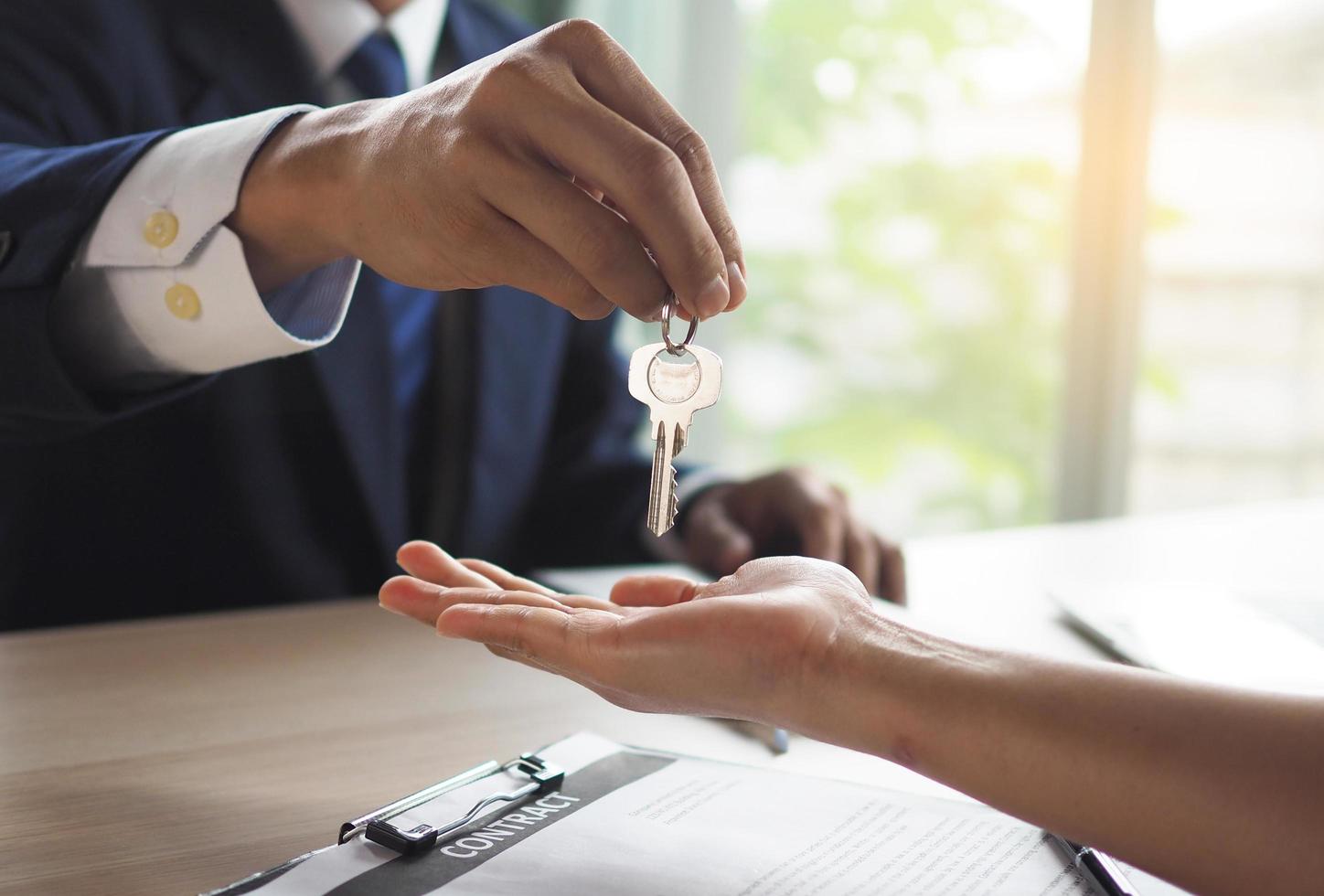 House salesmen are sending keys to new homeowners.  Buying, selling, renting, changing homes photo