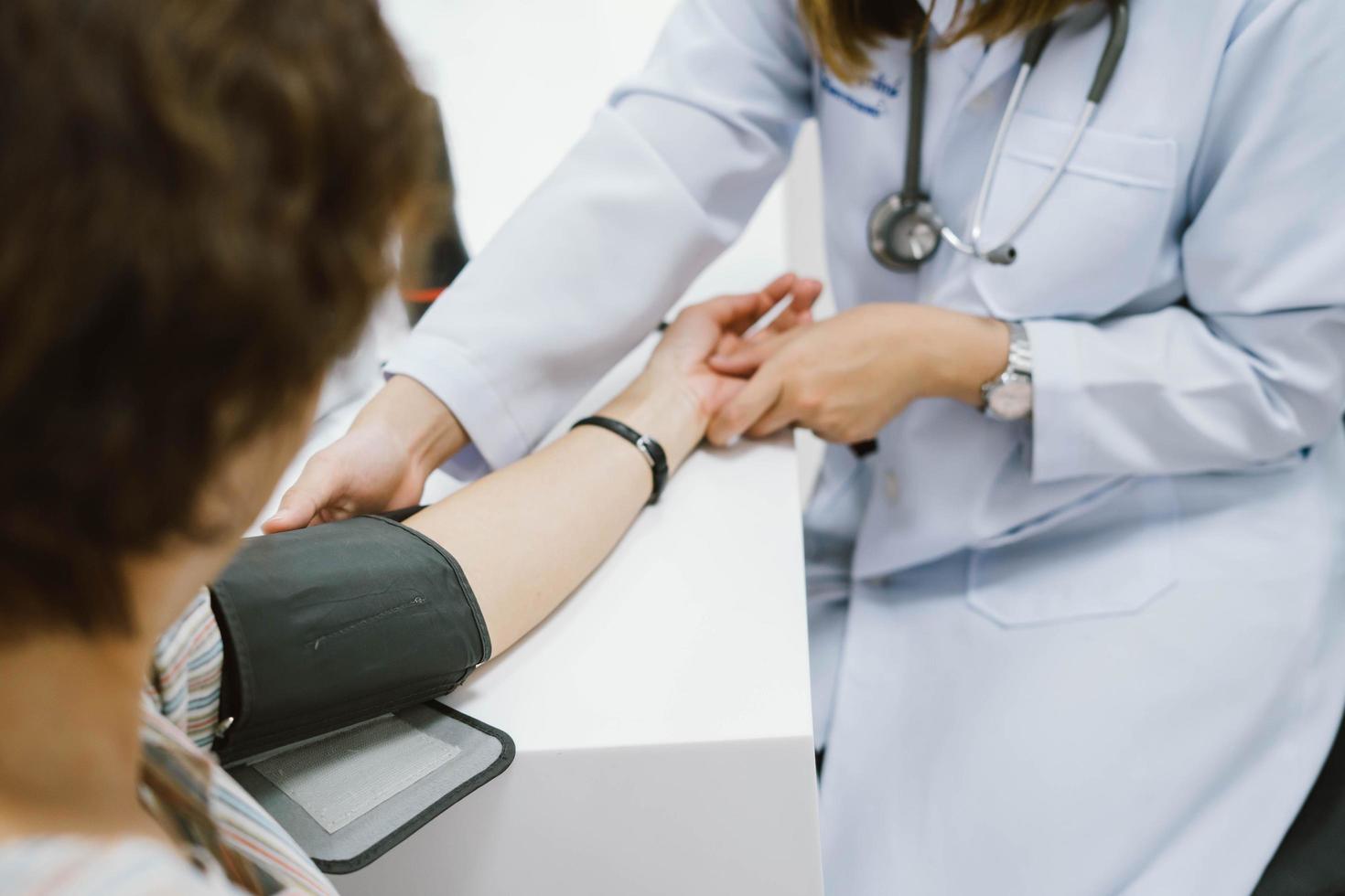 close up doctor checking senior patient blood pressure. Health care. photo