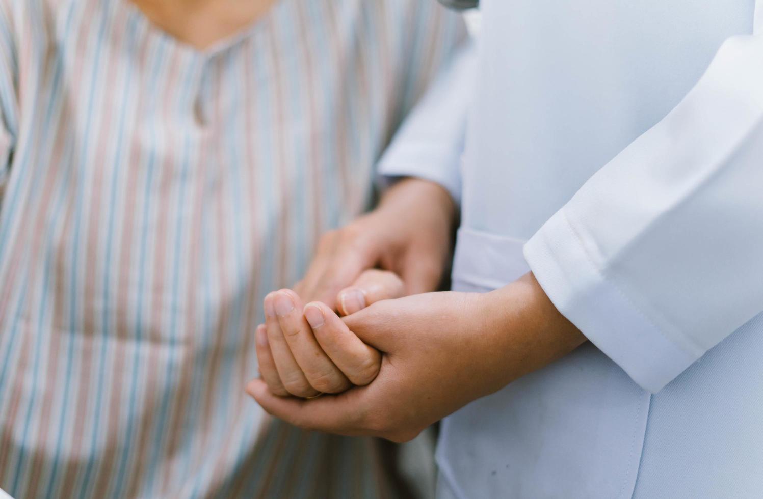 close up doctor hold hand of senior patient , medical care responsibility photo