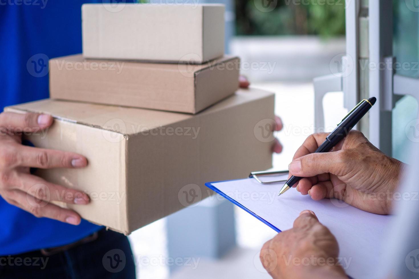 The housekeeper is signing to receive the product from the hands of the male delivery staff. Shopping at home and fast home delivery service photo
