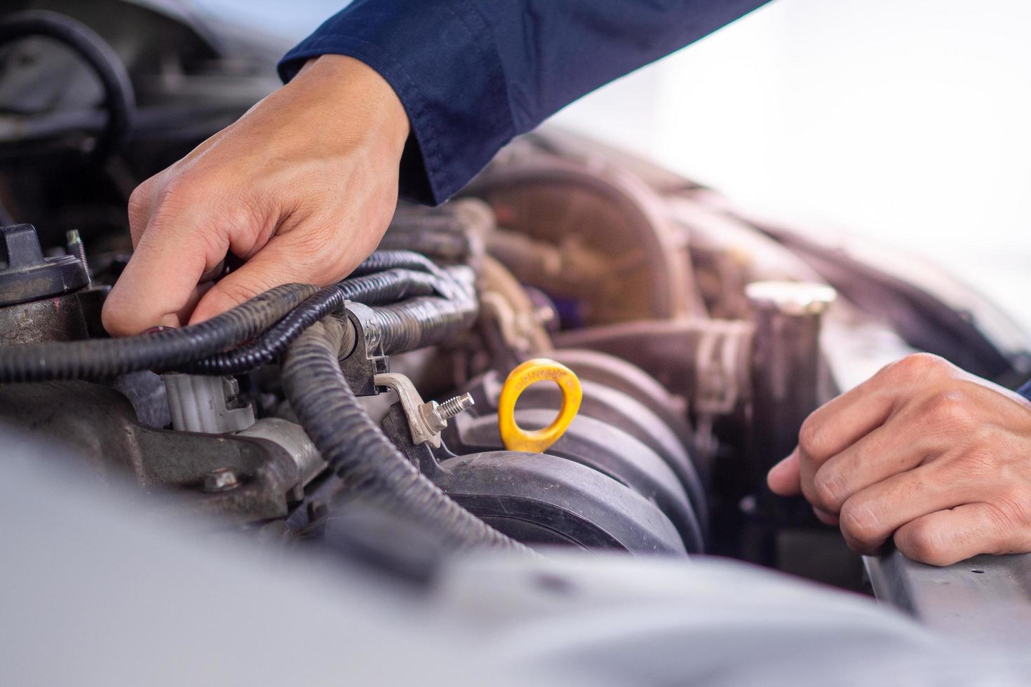 The maintenance technician is checking the condition of the engine to be ready for use. In the car service center. Concept of car maintenance photo