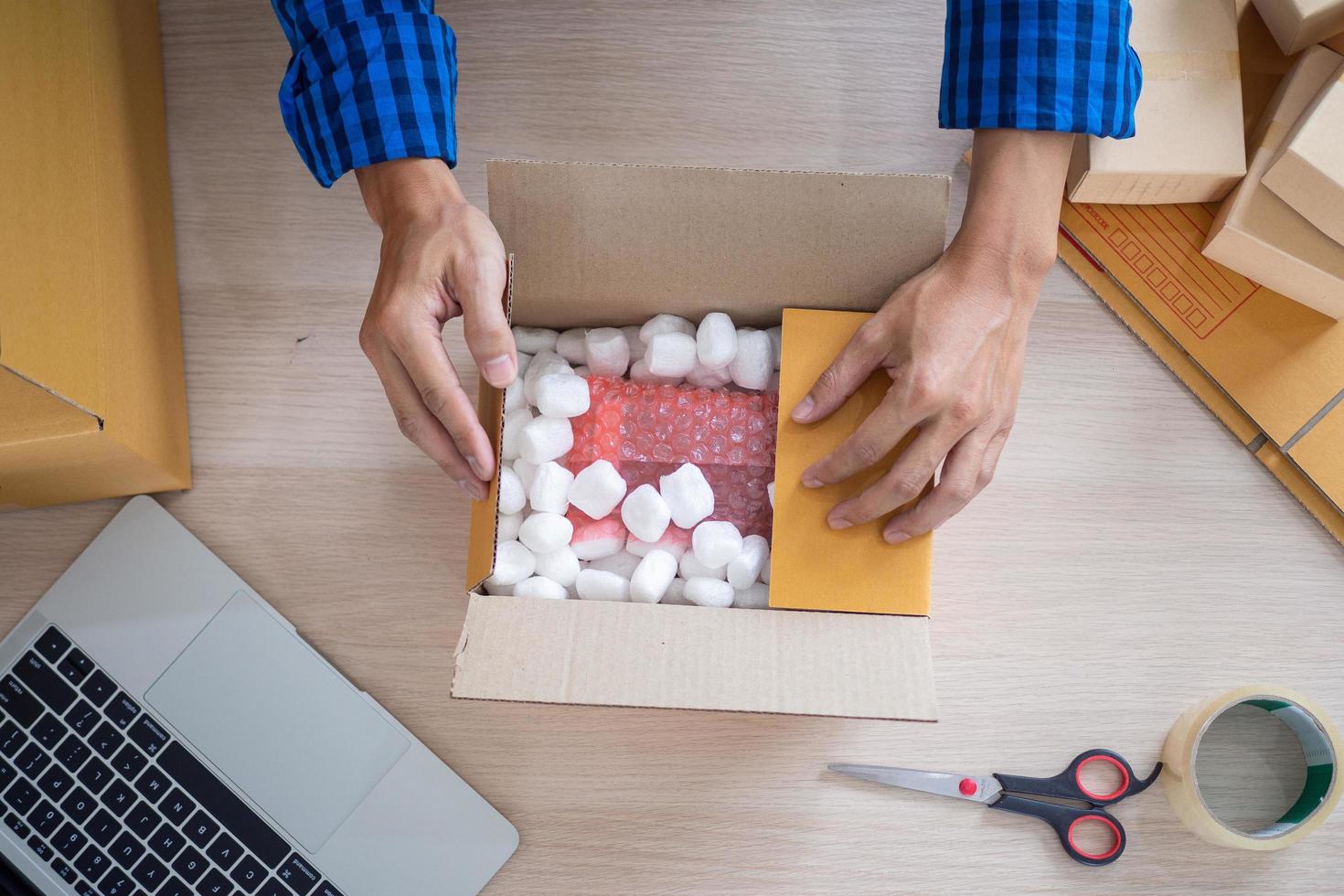 Online merchants packing items into paper boxes. In order to deliver parcels to customers. deliver the product according to the order from the online buyer. Delivered quickly to home, small businesses photo