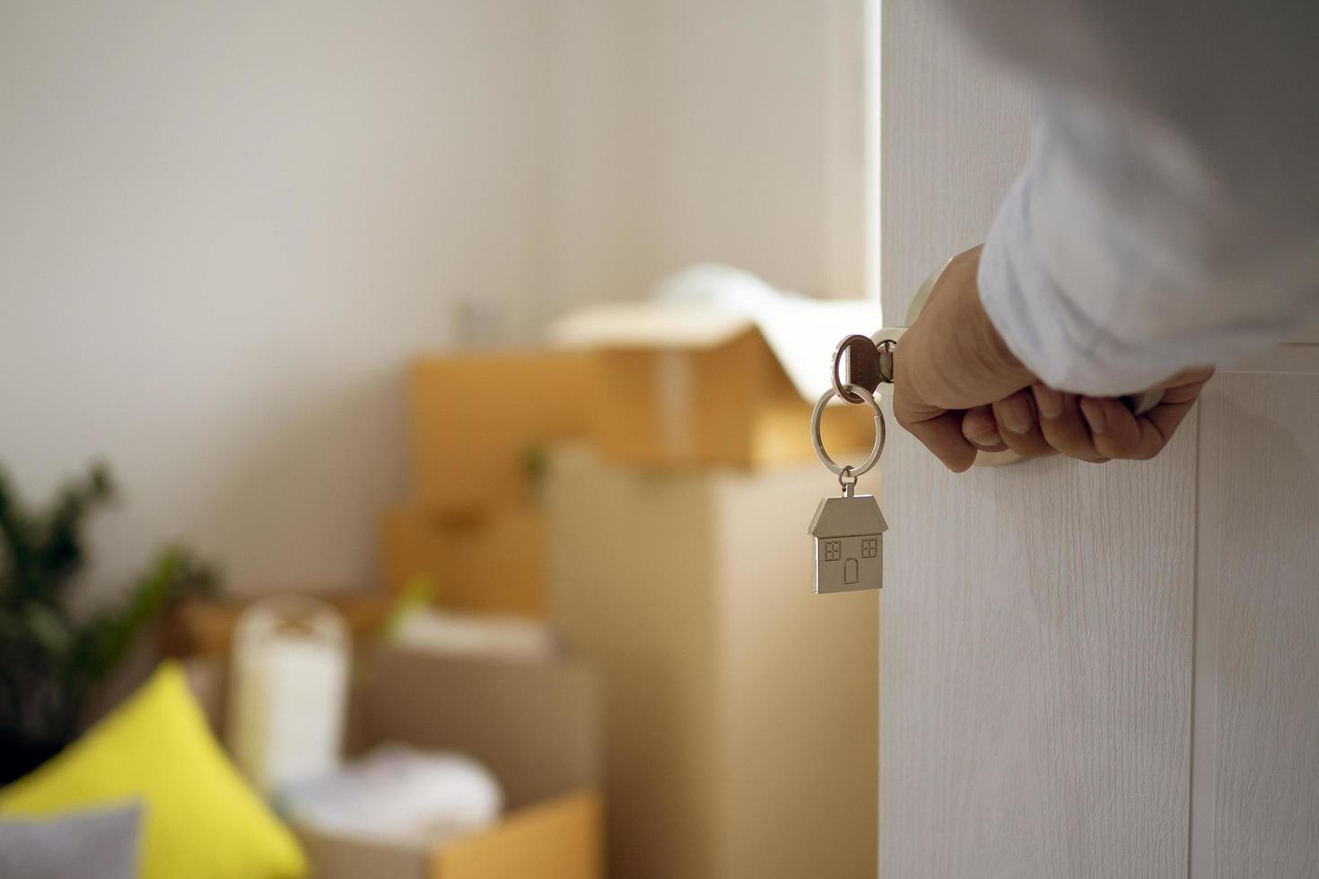 The new house owner opens the door. With personal items after moving the house in the background photo