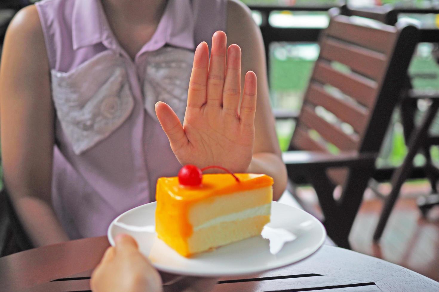 el mujer son perdiendo peso. escoger no a obtener un plato de pastel ese amigos enviar. foto