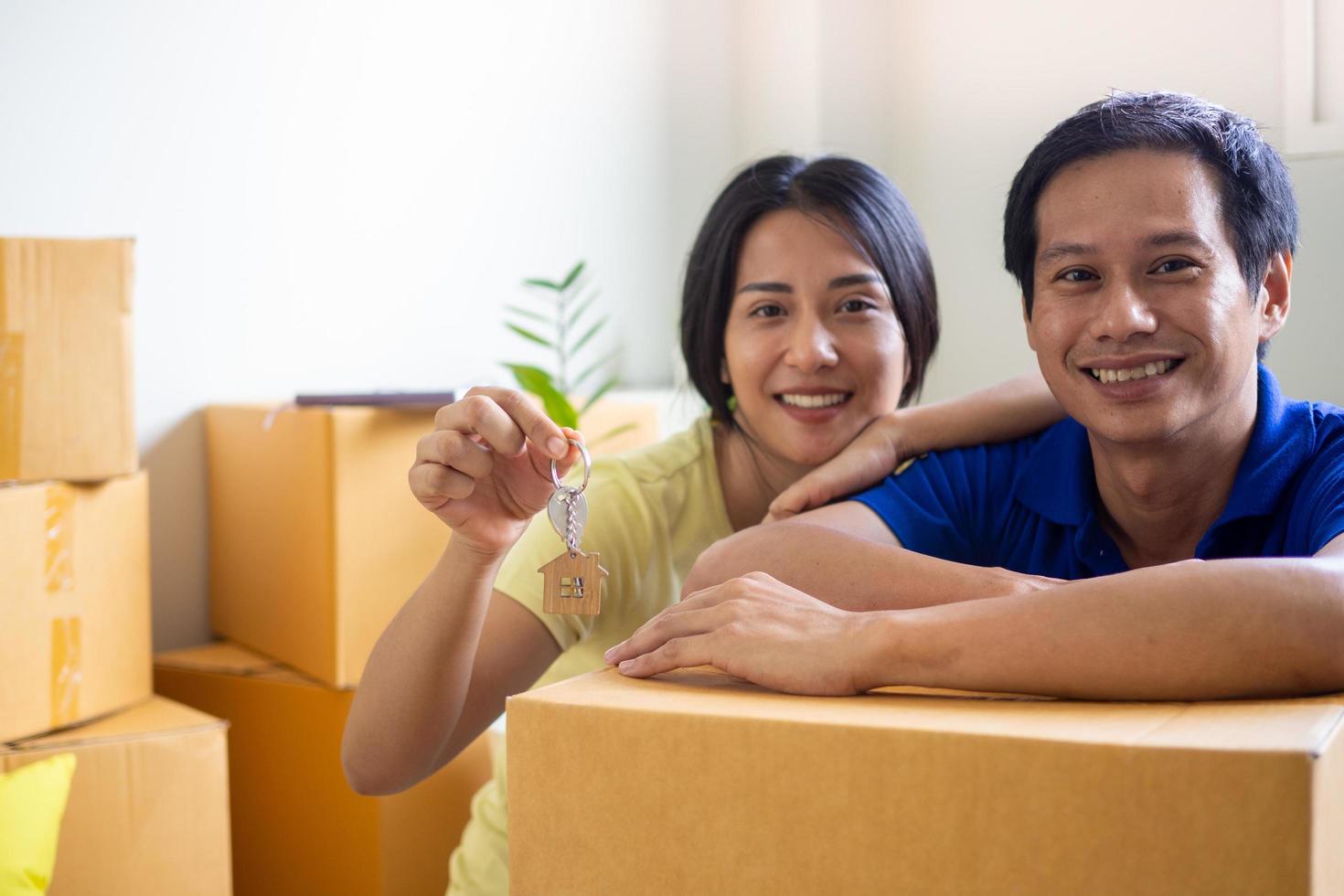 el Pareja retenida el casa llaves y sonrió, disfrutando Moviente a un nuevo casa. foto