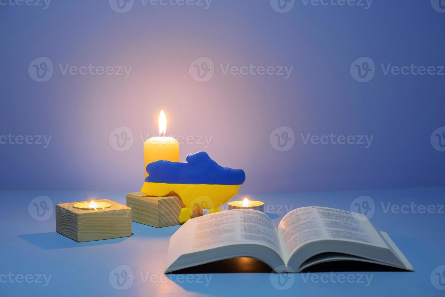 Christian Holy Bible with candles lighting on blue background photo