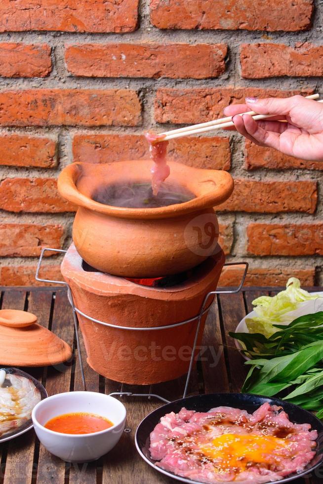 Hot pot thai style. Hot pot with clear soup in the clay cooking pot. photo