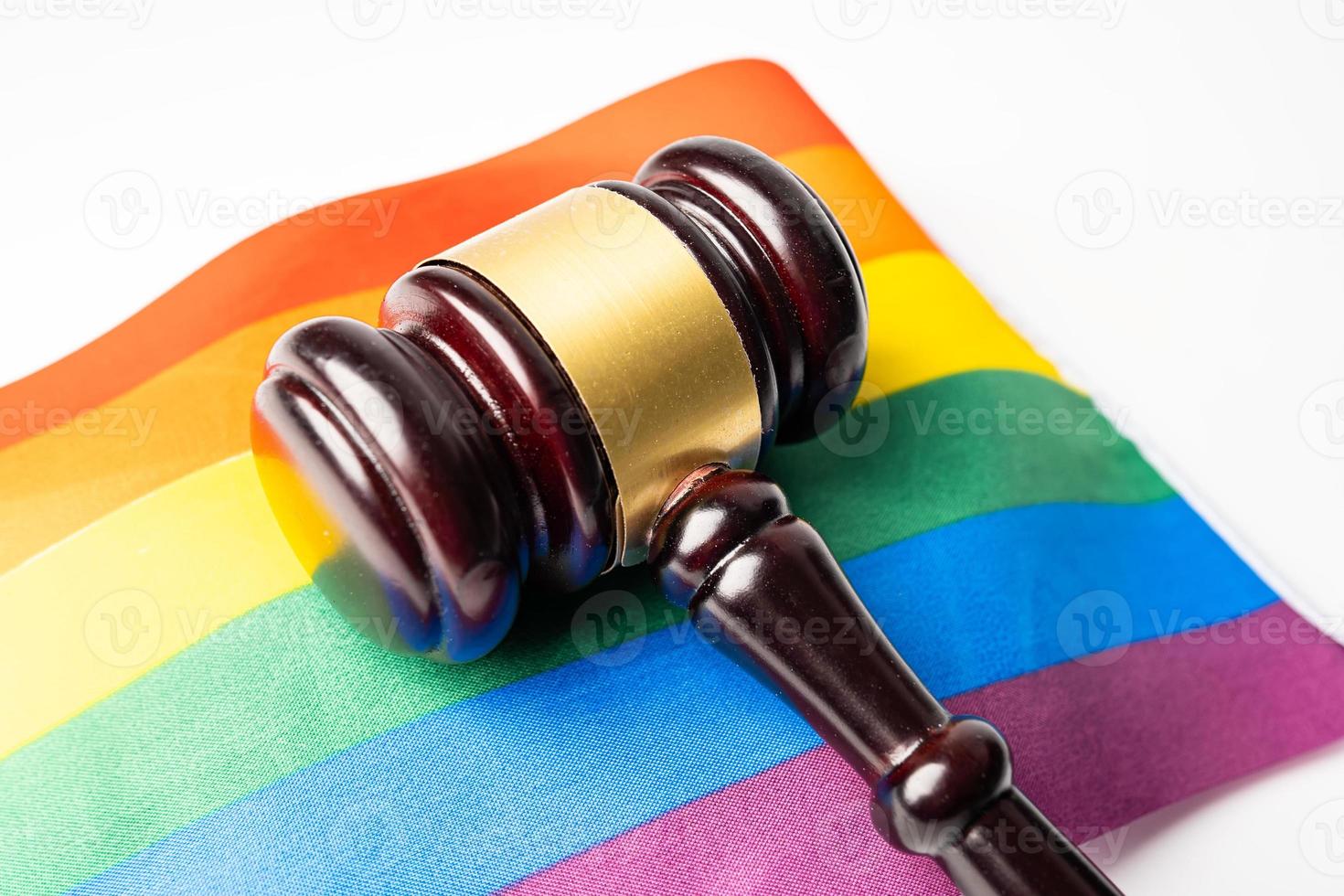 martillo para juez abogado en la bandera del arco iris, símbolo del mes del orgullo lgbt celebran anualmente en junio las redes sociales de gays, lesbianas, bisexuales, transgénero, derechos humanos. foto