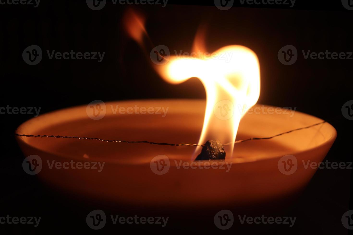 Blazing candle fire spark. Warm orange background. photo