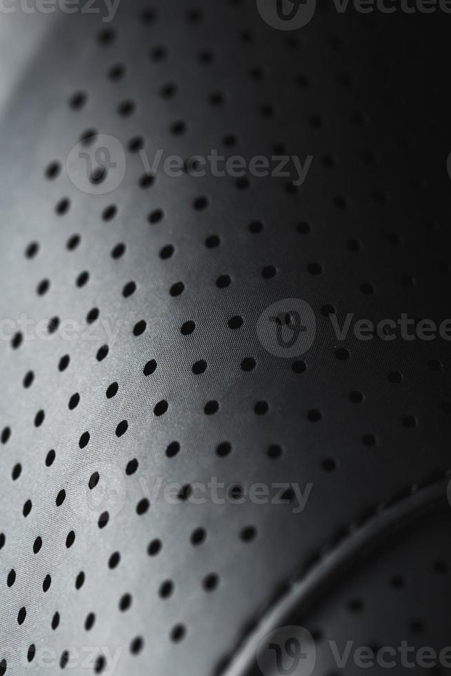 Perforated material made of black imitation leather in full screen photo