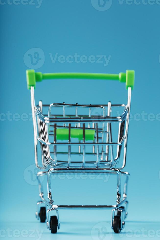 An empty supermarket cart on a blue background. photo