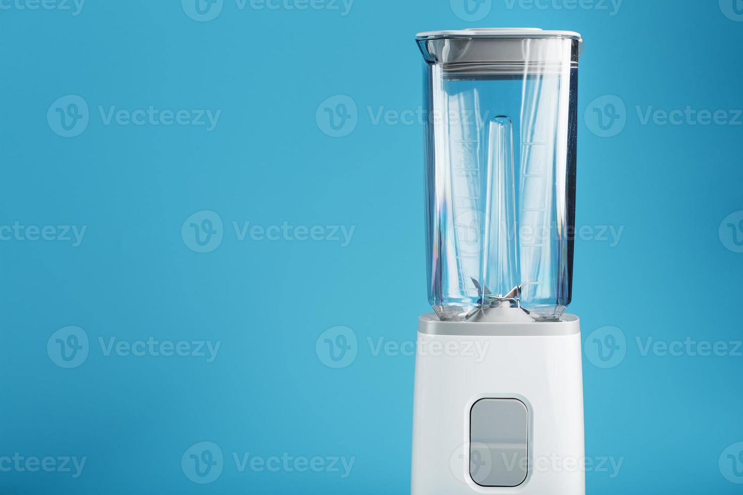 Blender with a cup on a blue background with free space a photo