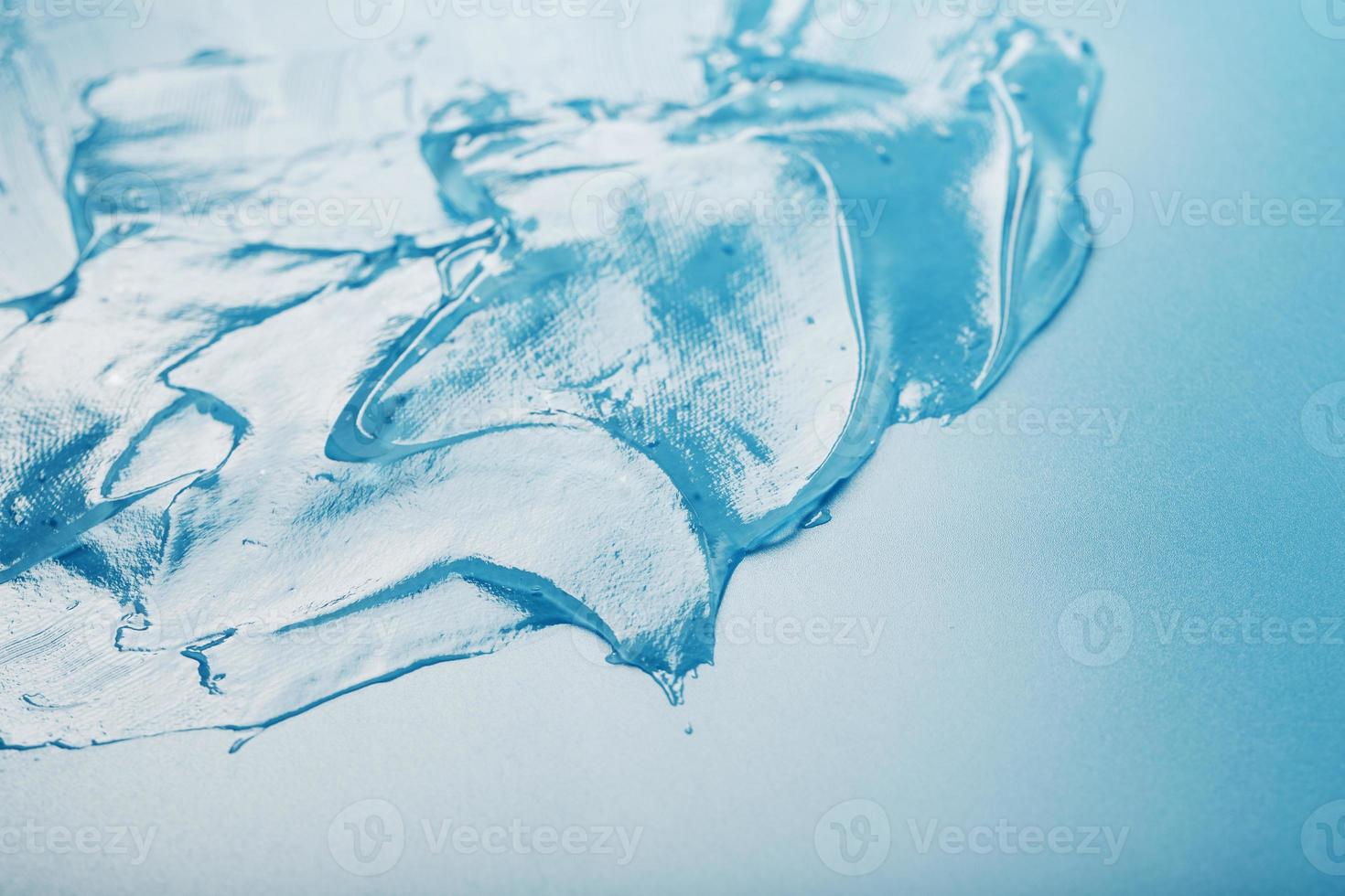 Gel with hyaluronic acid in the form of a smear of glossy texture on a blue background. photo