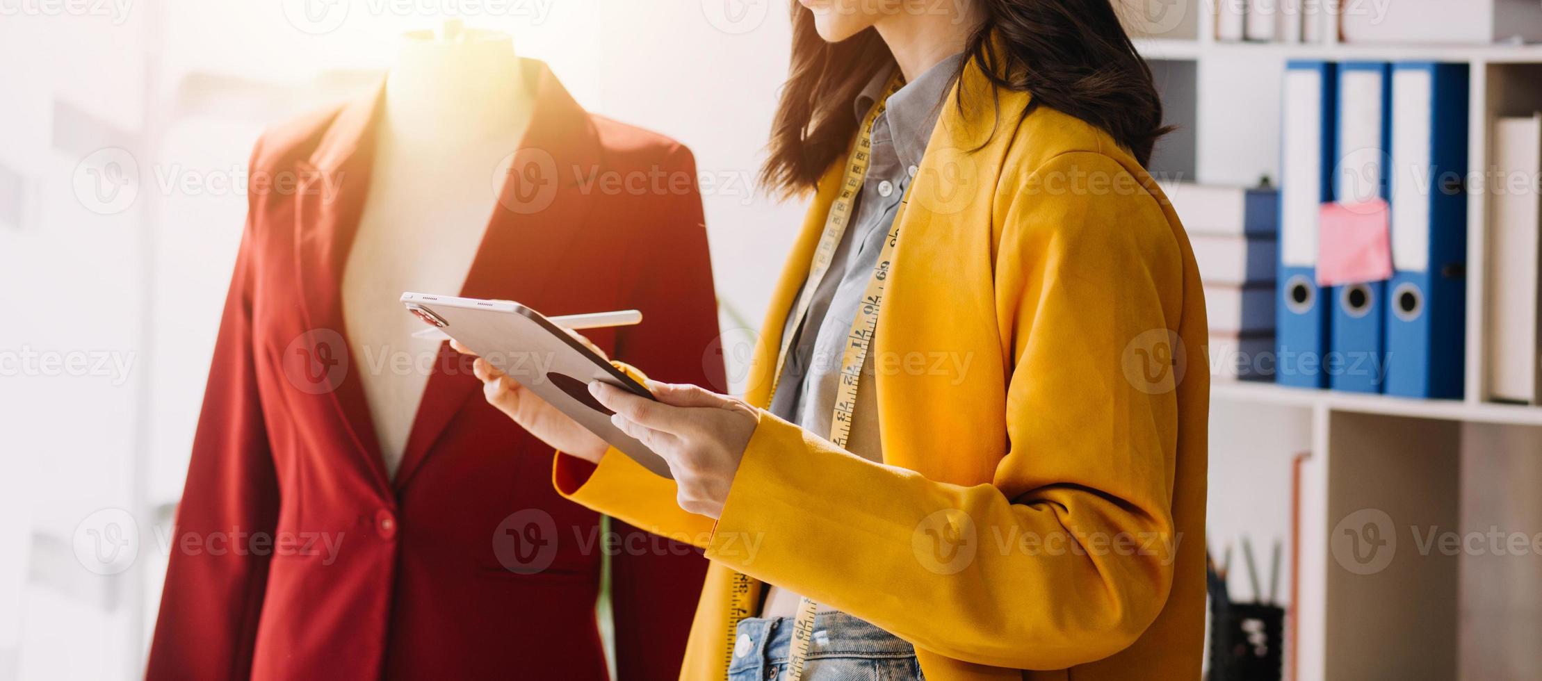 Beautiful lady blogger showing clothes in front of the camera to recording vlog video live streaming at her shop. Online Shopping Cart notion. photo