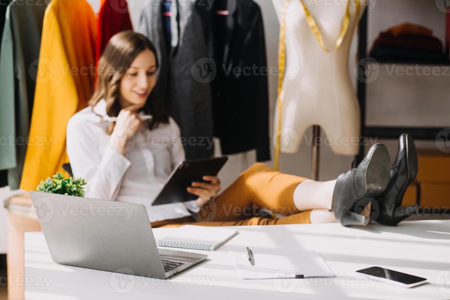 Beautiful lady blogger showing clothes in front of the camera to recording vlog video live streaming at her shop. Online Shopping Cart notion. photo