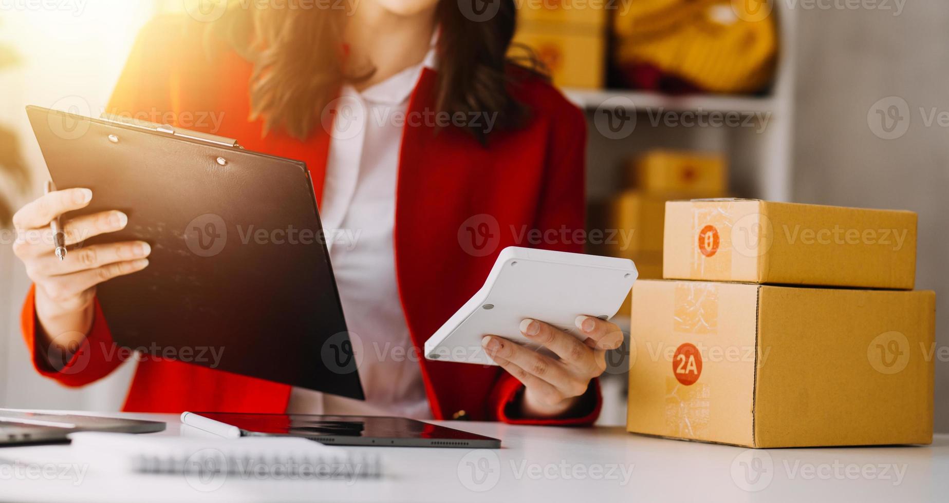 Beautiful lady blogger showing clothes in front of the camera to recording vlog video live streaming at her shop. Online Shopping Cart notion. photo