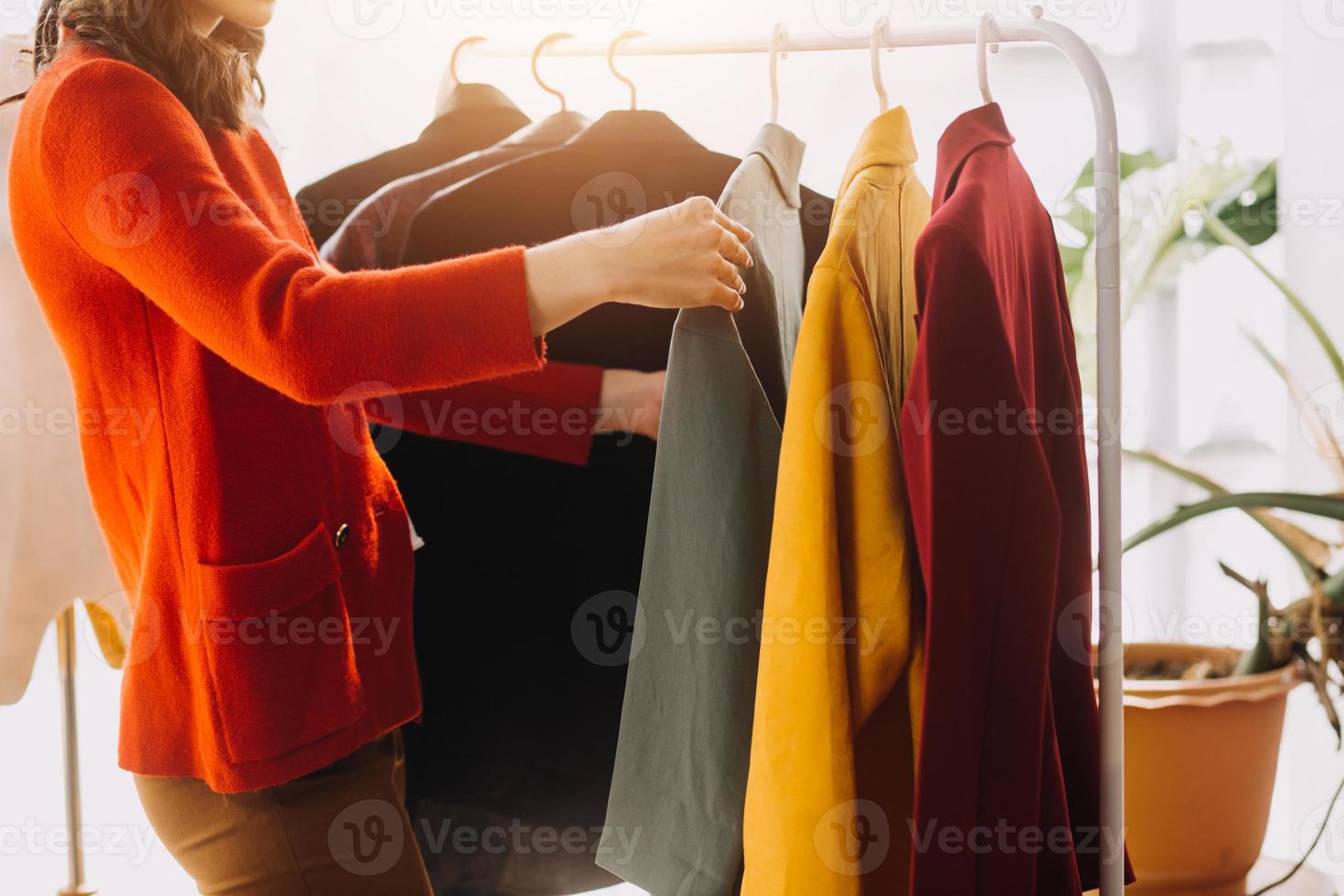 Beautiful lady blogger showing clothes in front of the camera to recording vlog video live streaming at her shop. Online Shopping Cart notion. photo