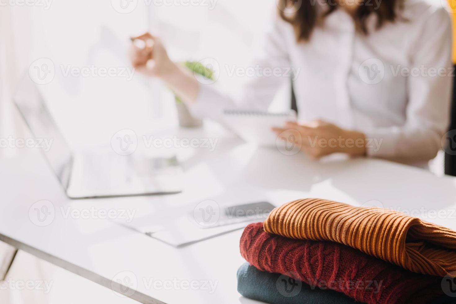 Beautiful lady blogger showing clothes in front of the camera to recording vlog video live streaming at her shop. Online Shopping Cart notion. photo