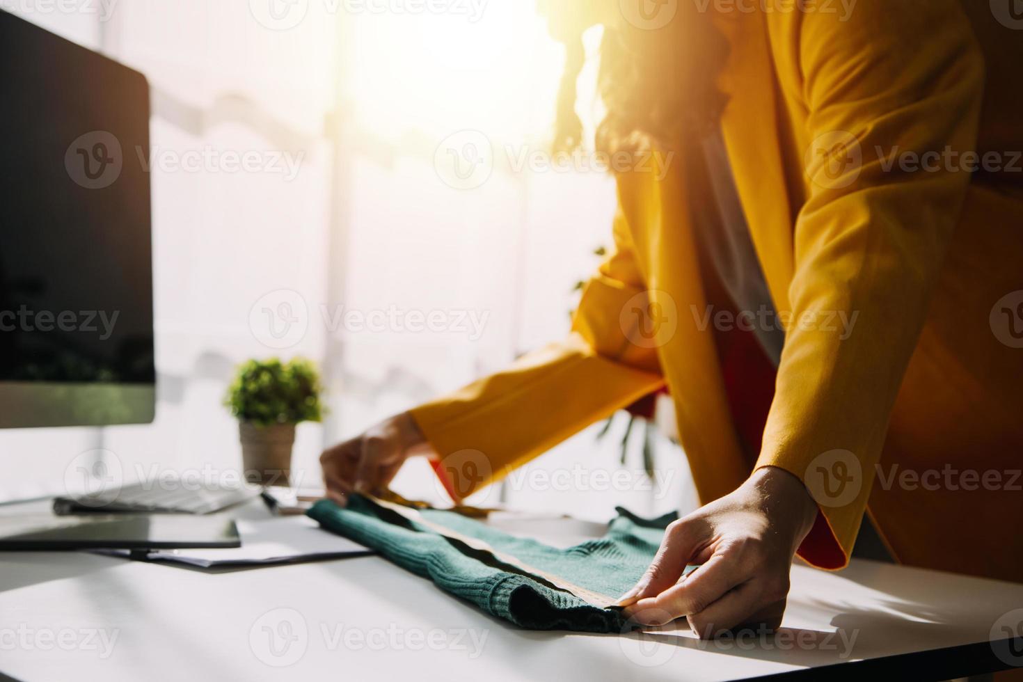 Beautiful lady blogger showing clothes in front of the camera to recording vlog video live streaming at her shop. Online Shopping Cart notion. photo