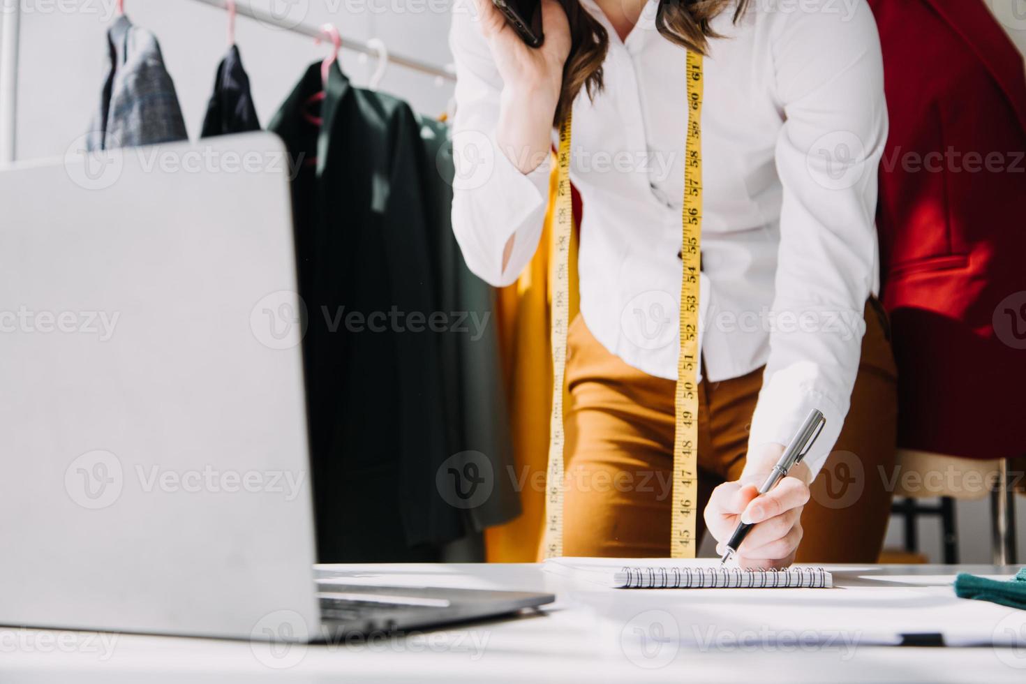 Beautiful lady blogger showing clothes in front of the camera to recording vlog video live streaming at her shop. Online Shopping Cart notion. photo