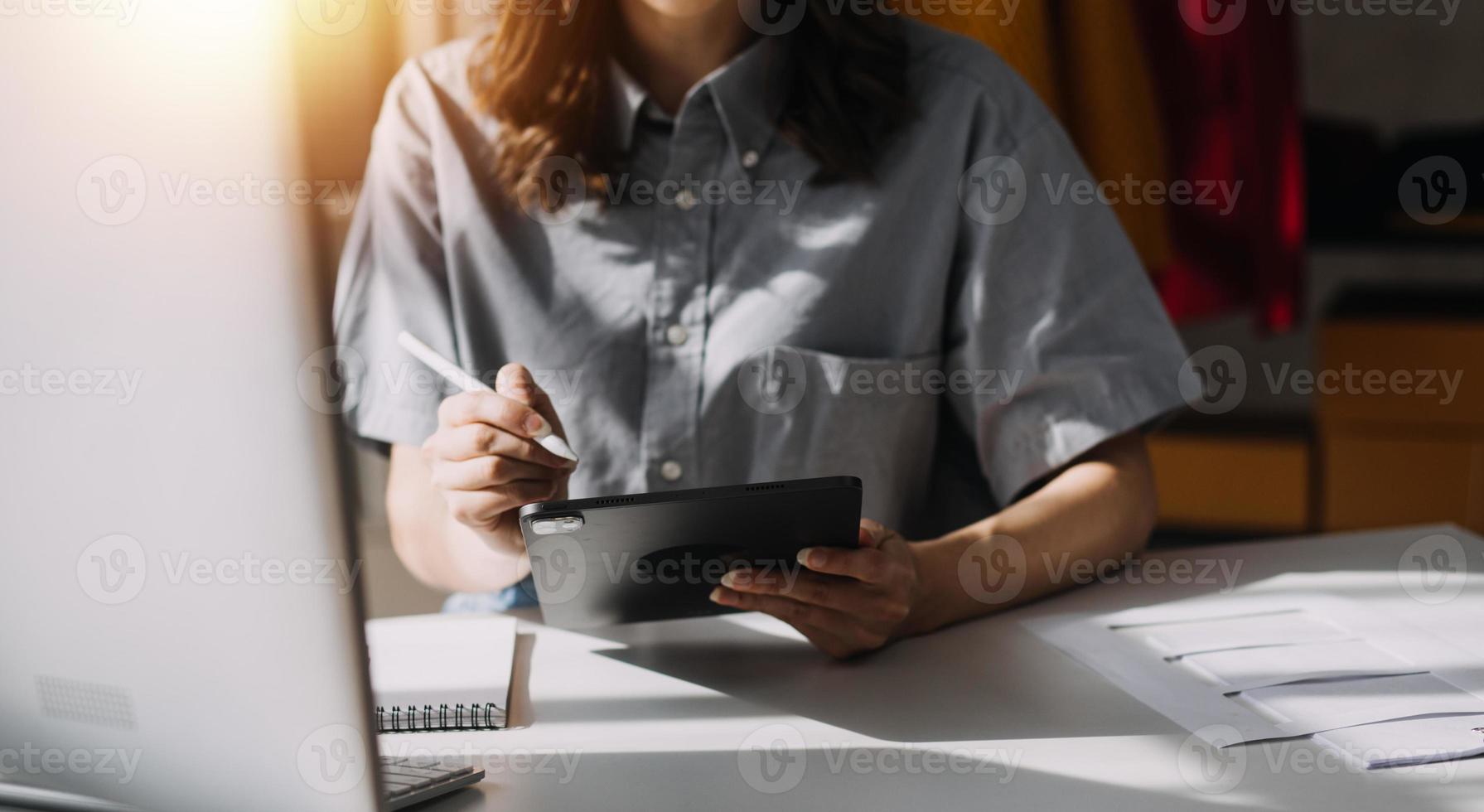 Beautiful lady blogger showing clothes in front of the camera to recording vlog video live streaming at her shop. Online Shopping Cart notion. photo