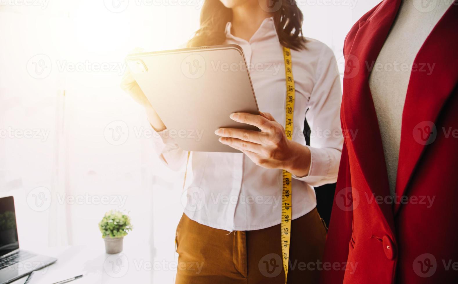 Beautiful lady blogger showing clothes in front of the camera to recording vlog video live streaming at her shop. Online Shopping Cart notion. photo