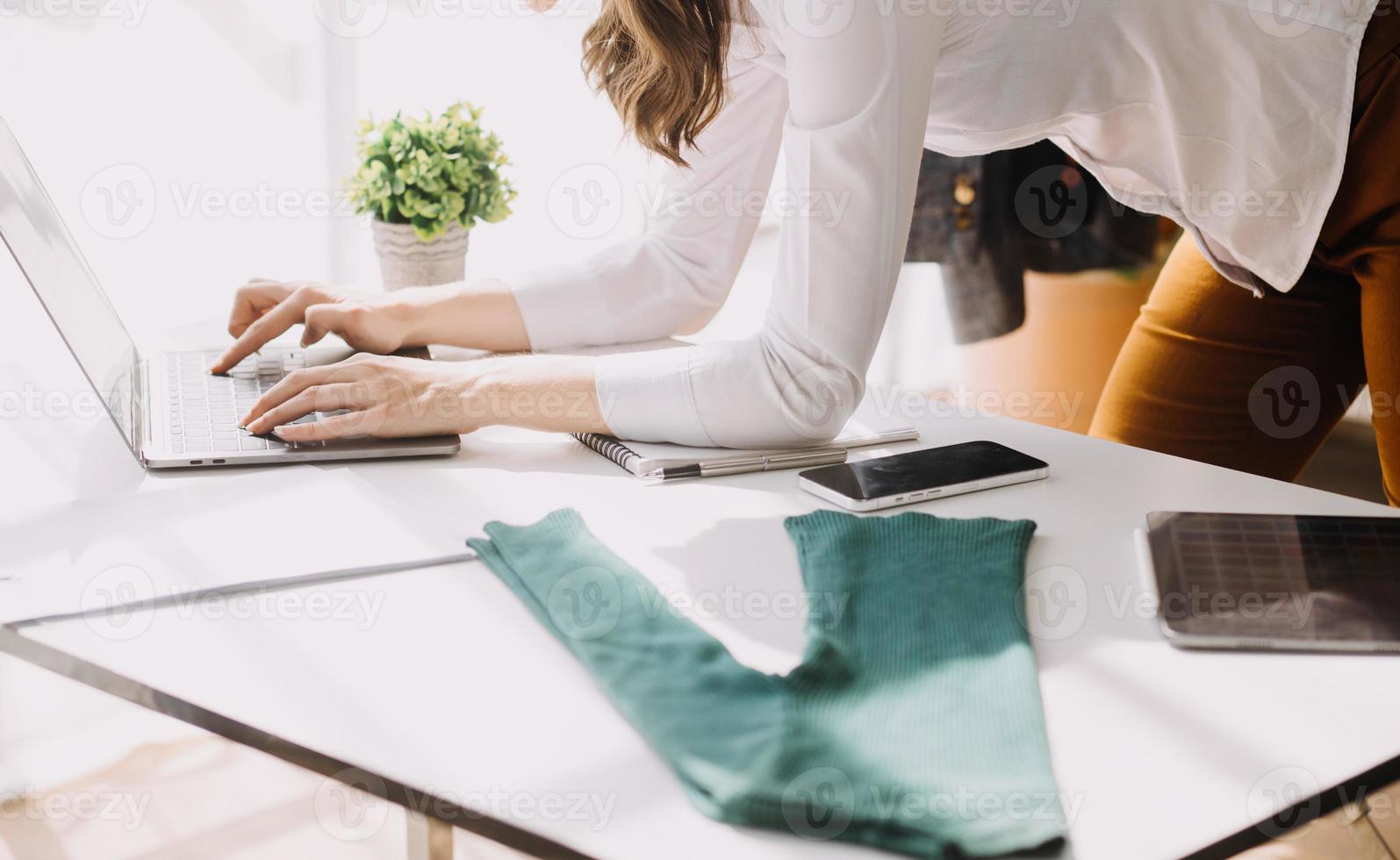 Beautiful lady blogger showing clothes in front of the camera to recording vlog video live streaming at her shop. Online Shopping Cart notion. photo