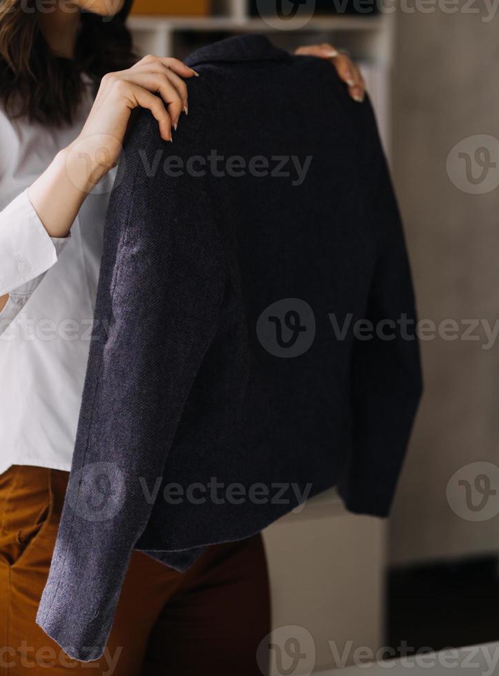 Beautiful lady blogger showing clothes in front of the camera to recording vlog video live streaming at her shop. Online Shopping Cart notion. photo