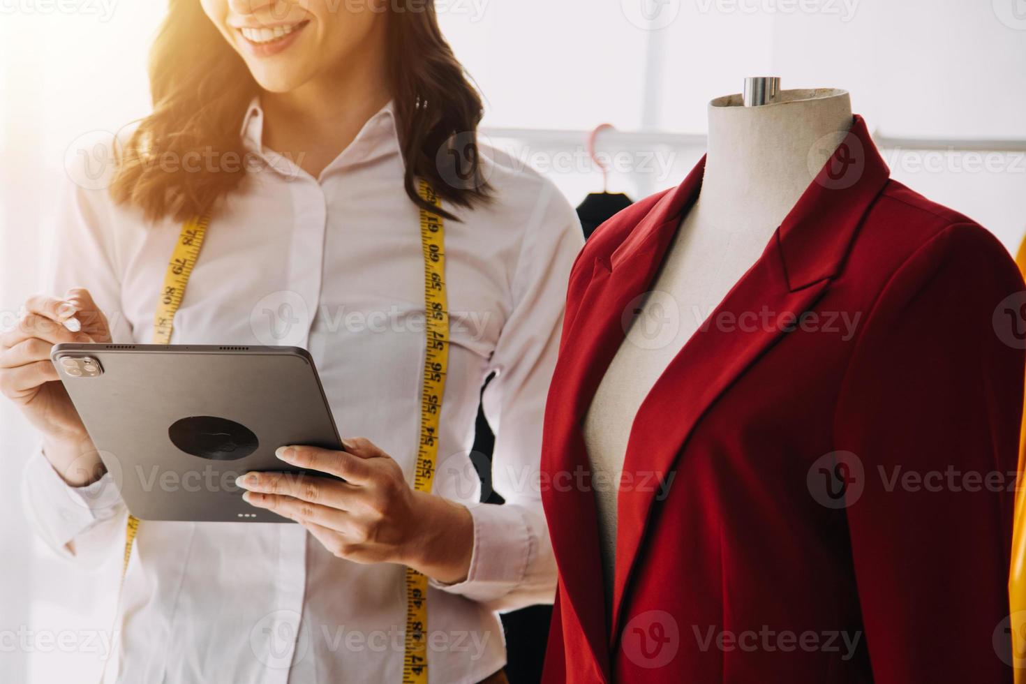 Beautiful lady blogger showing clothes in front of the camera to recording vlog video live streaming at her shop. Online Shopping Cart notion. photo