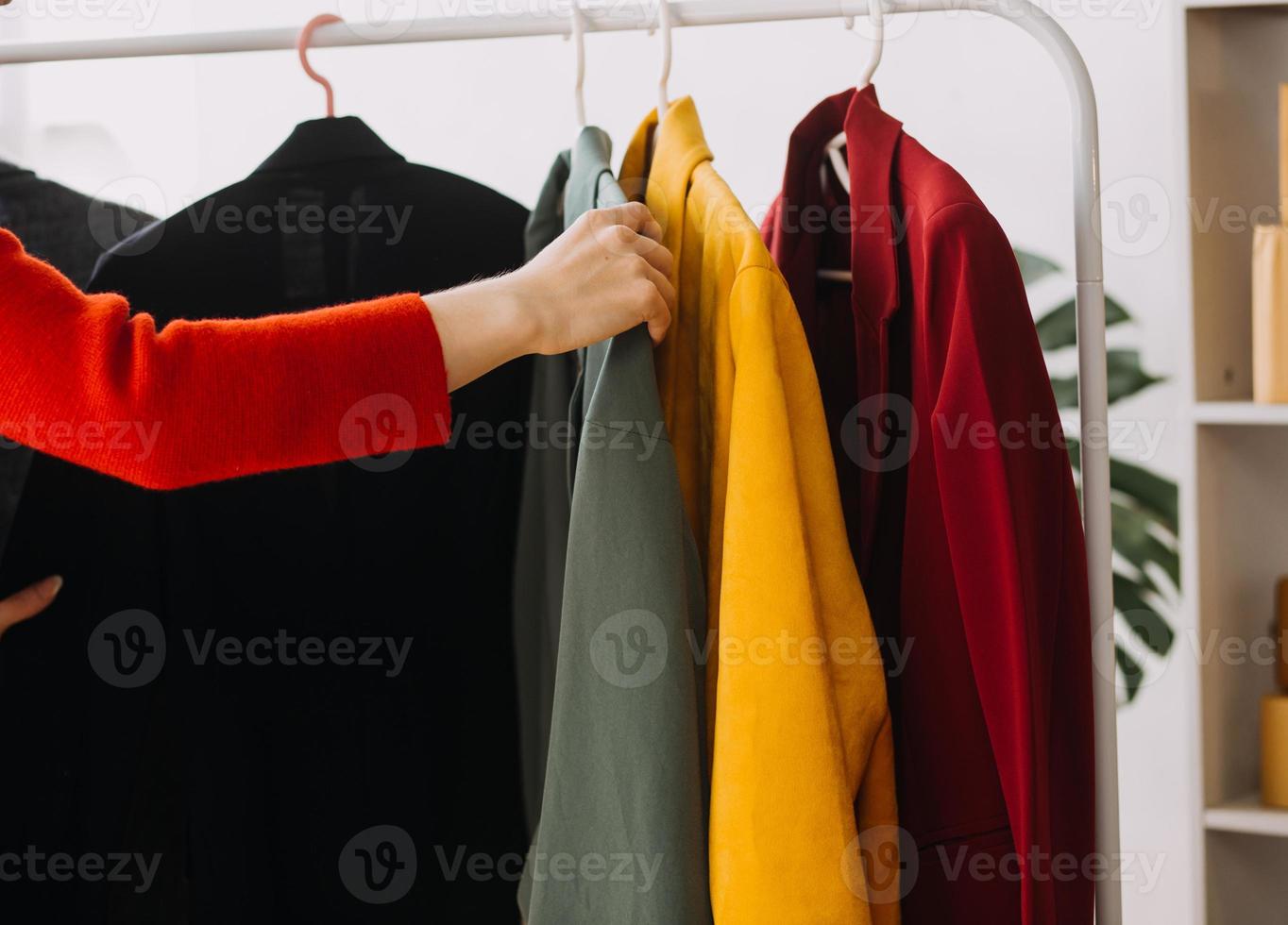Beautiful lady blogger showing clothes in front of the camera to recording vlog video live streaming at her shop. Online Shopping Cart notion. photo