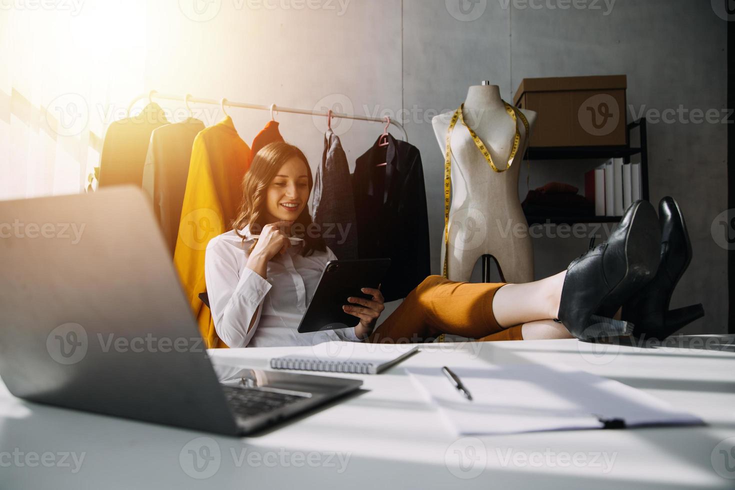 Beautiful lady blogger showing clothes in front of the camera to recording vlog video live streaming at her shop. Online Shopping Cart notion. photo