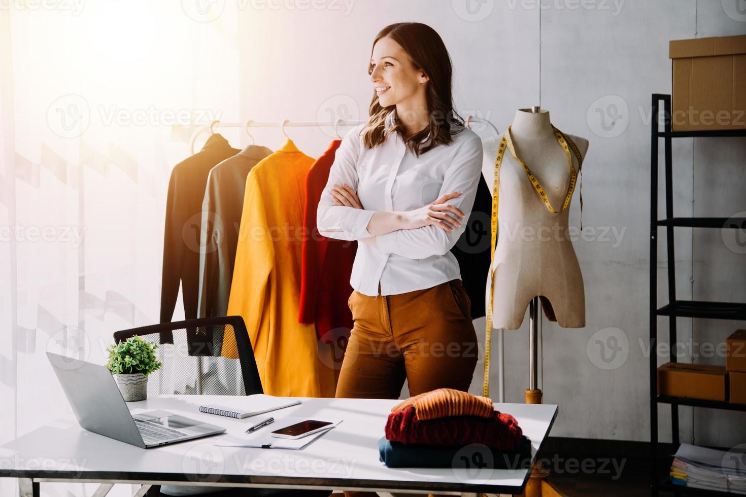 Beautiful lady blogger showing clothes in front of the camera to recording vlog video live streaming at her shop. Online Shopping Cart notion. photo