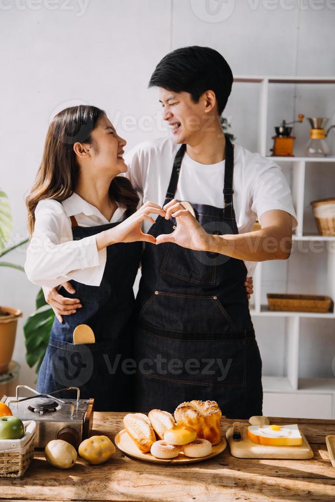 en cocina perfectamente contento Pareja preparando sano alimento, un montón de vegetales. hombre hace malabares con frutas, hace su Novia reír. encantador personas en amor tener divertido foto