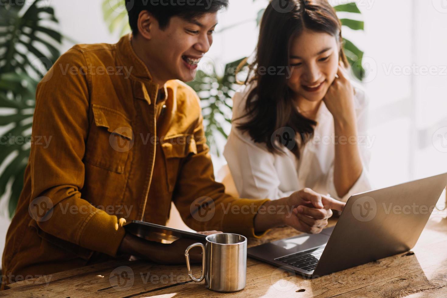 Entrepreneur Asian businessman and businesswoman discussing new business project in tablet in modern Meeting In Modern Office, Asian business casual concept. photo