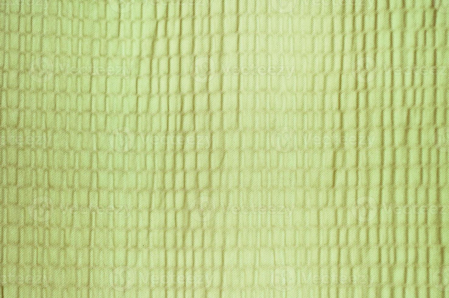 Bright green material background. Textile material texture with simple repetitive pattern. photo