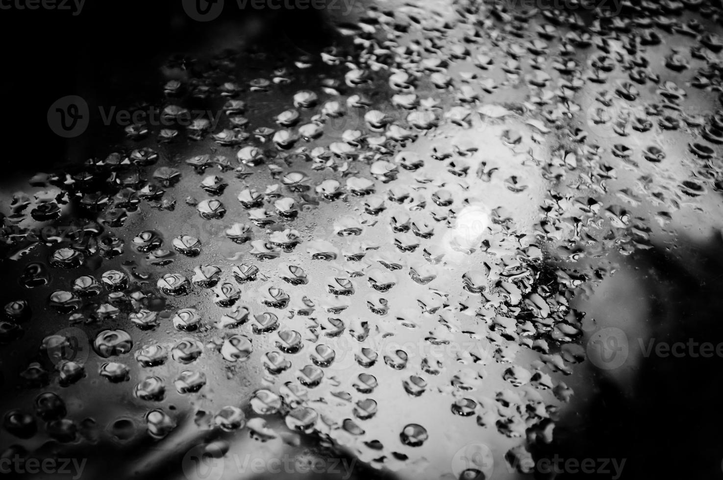 Black and white image of wet glass. Close up image of water droplets. photo