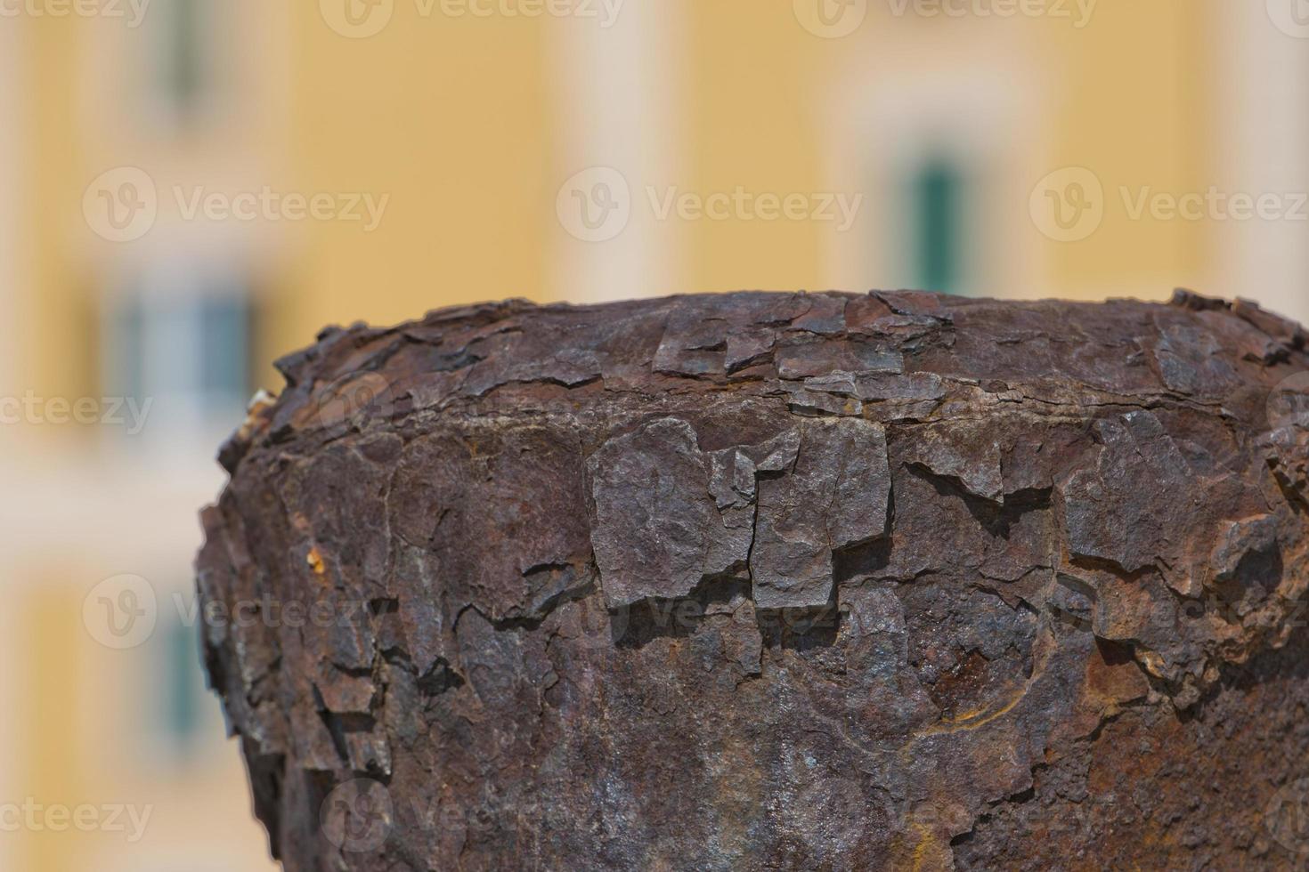 Rusted Bollard on colorful building background photo