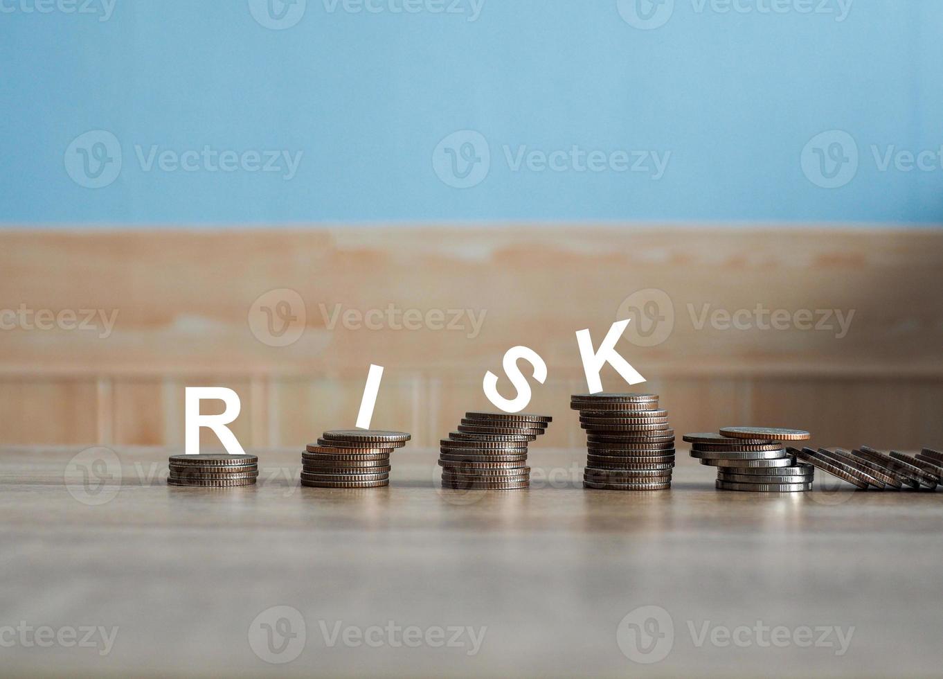 A pile of coins stacked in an unstable position. There is a risk word on top. Conducting financial business on risk photo