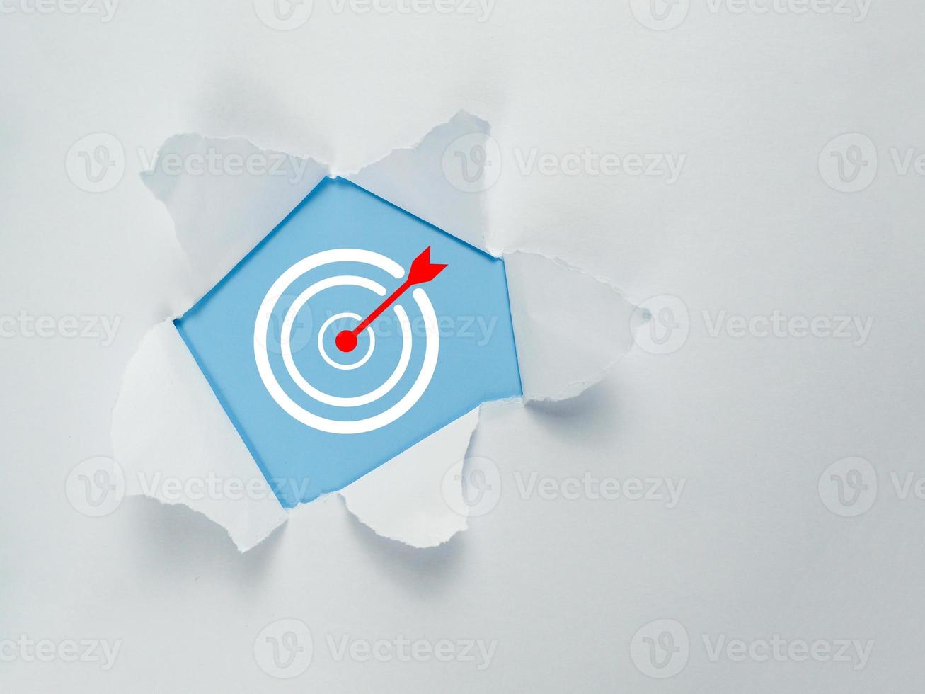 white torn paper with target icon inside empty space blue background photo