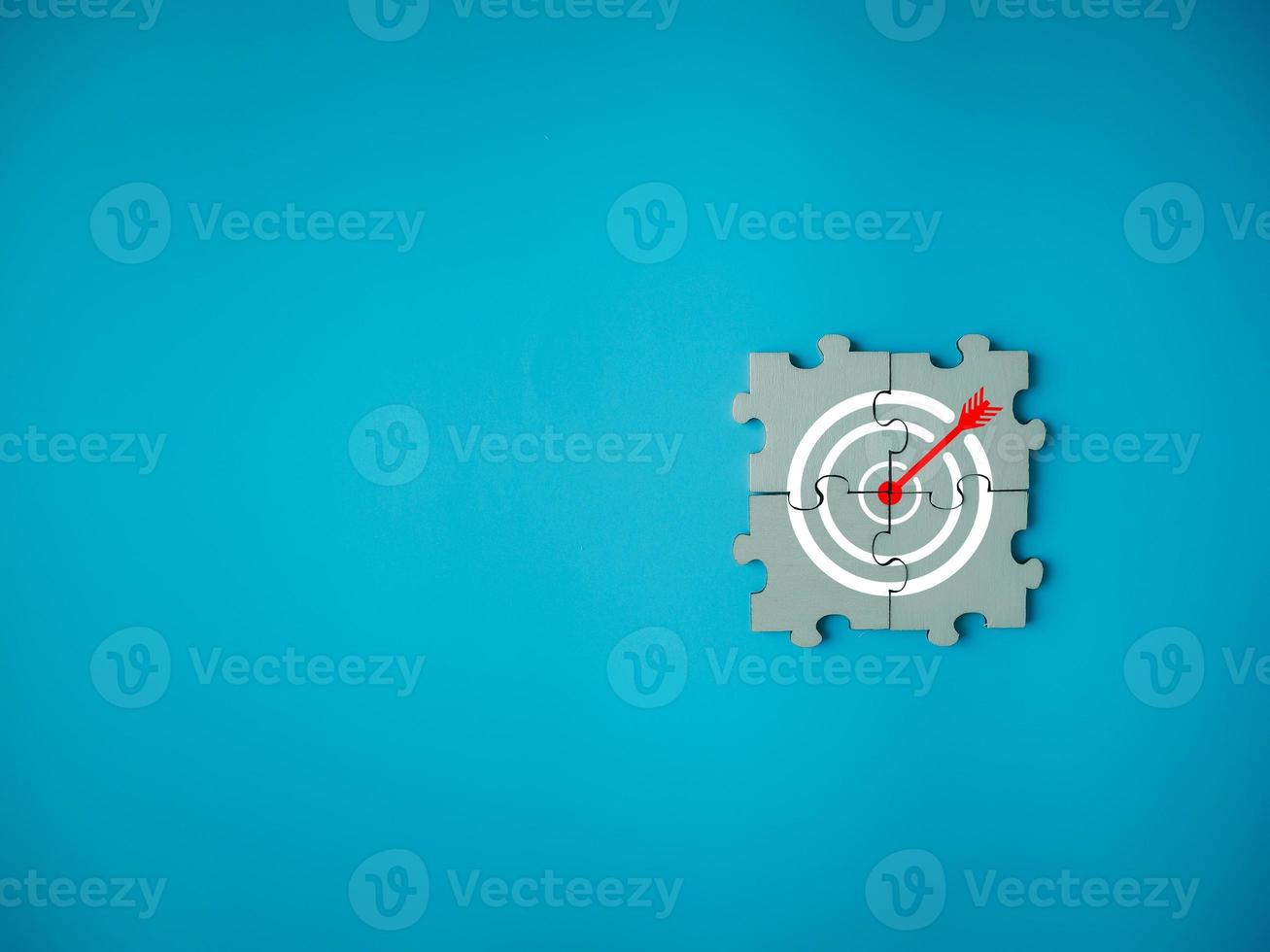target icon red arrow on jigsaw puzzle team cooperation success Brainstorming ideas to achieve goals on blue background photo