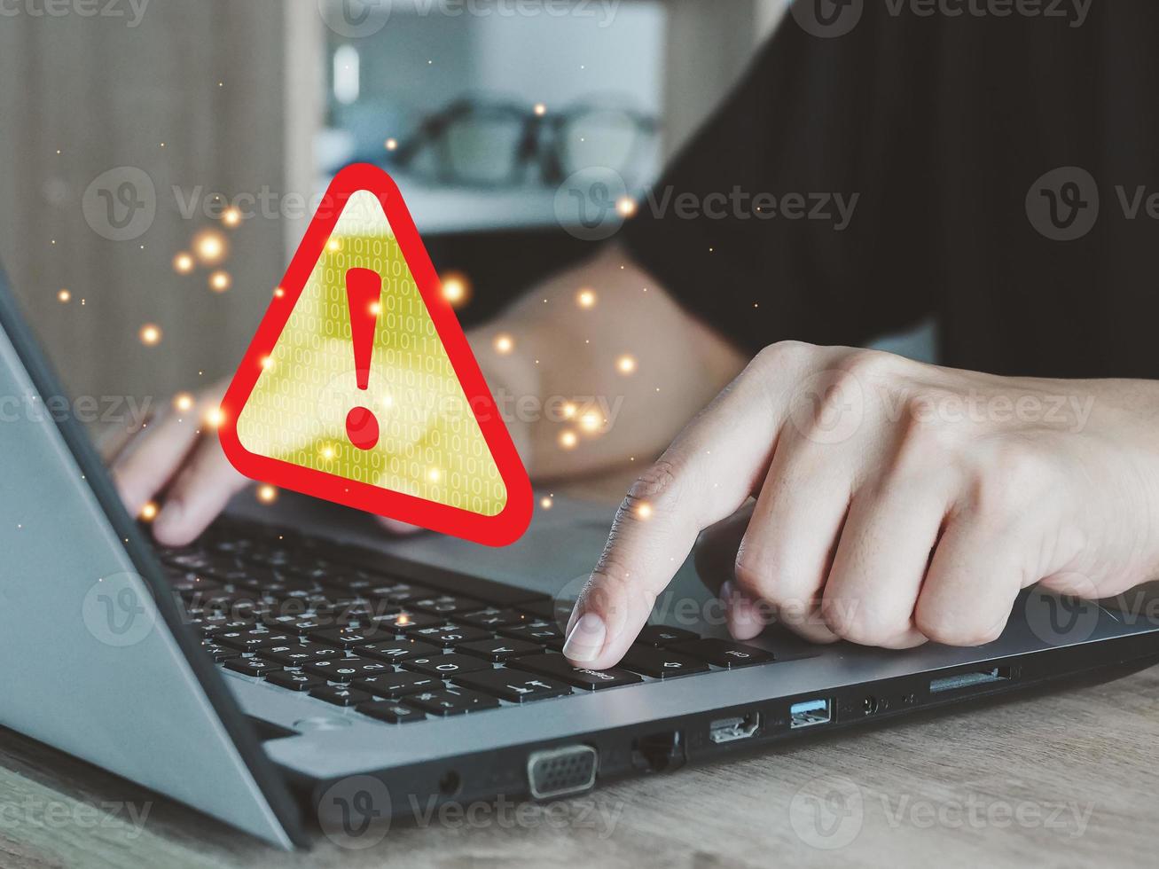 Male hand working through laptop and receiving warning triangle sign for error notification and maintenance concept. Document error display cyber attack photo