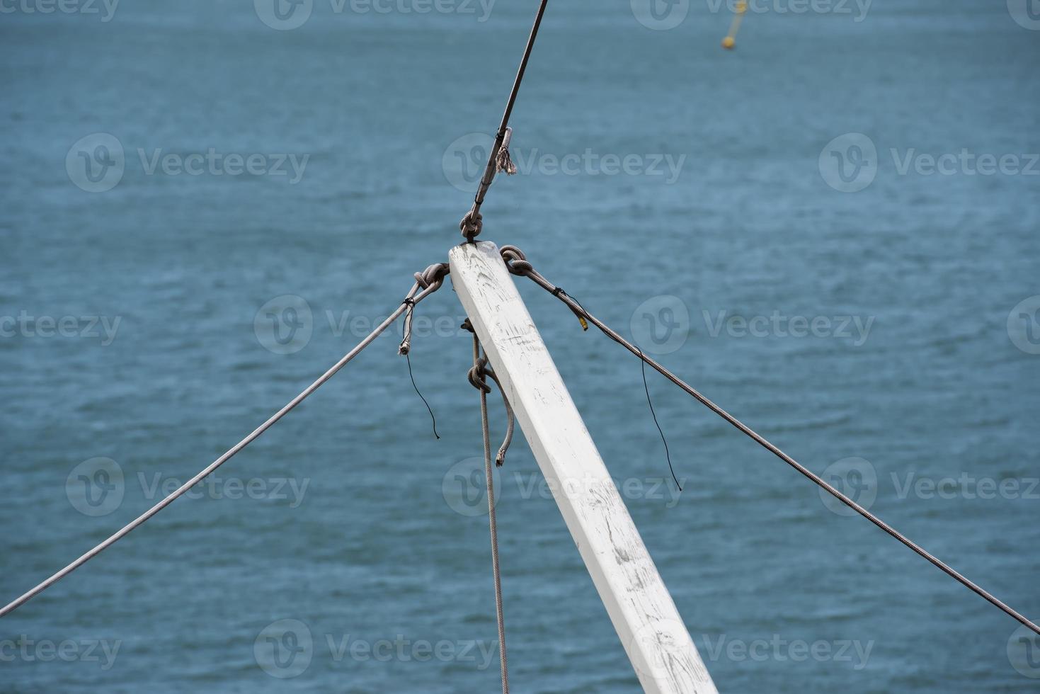 Wood white yard with ropes on blue sea background photo