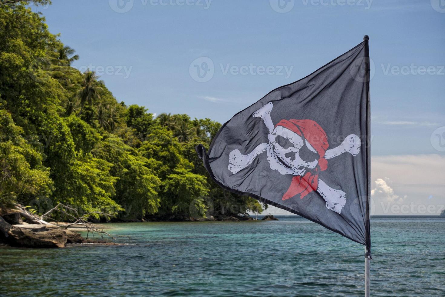 waving pirate flag jolly roger on tropical island background photo