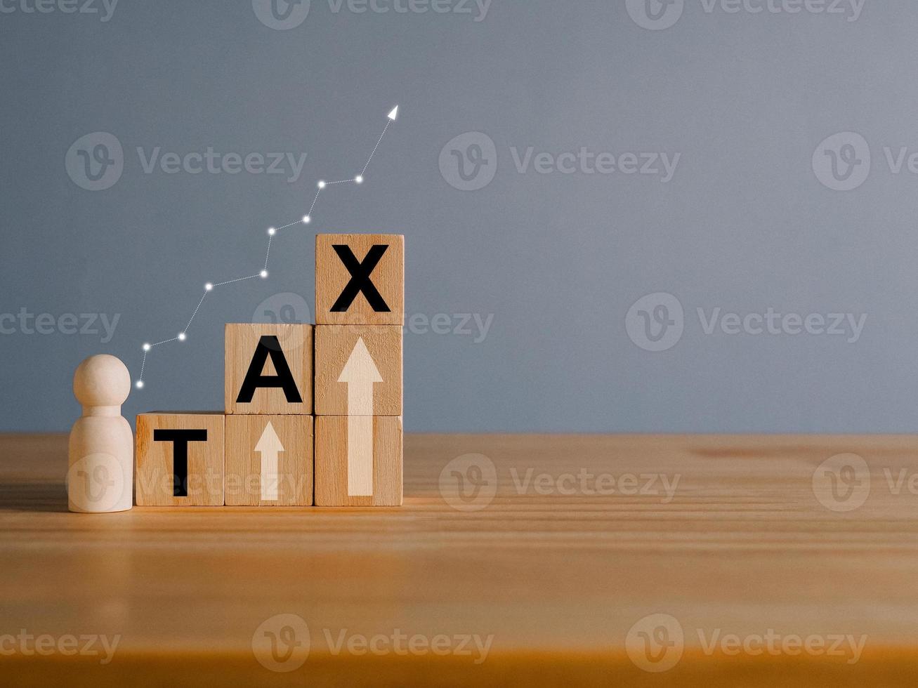 Tax concept with rising wooden blocks Expenses that are running higher than income photo