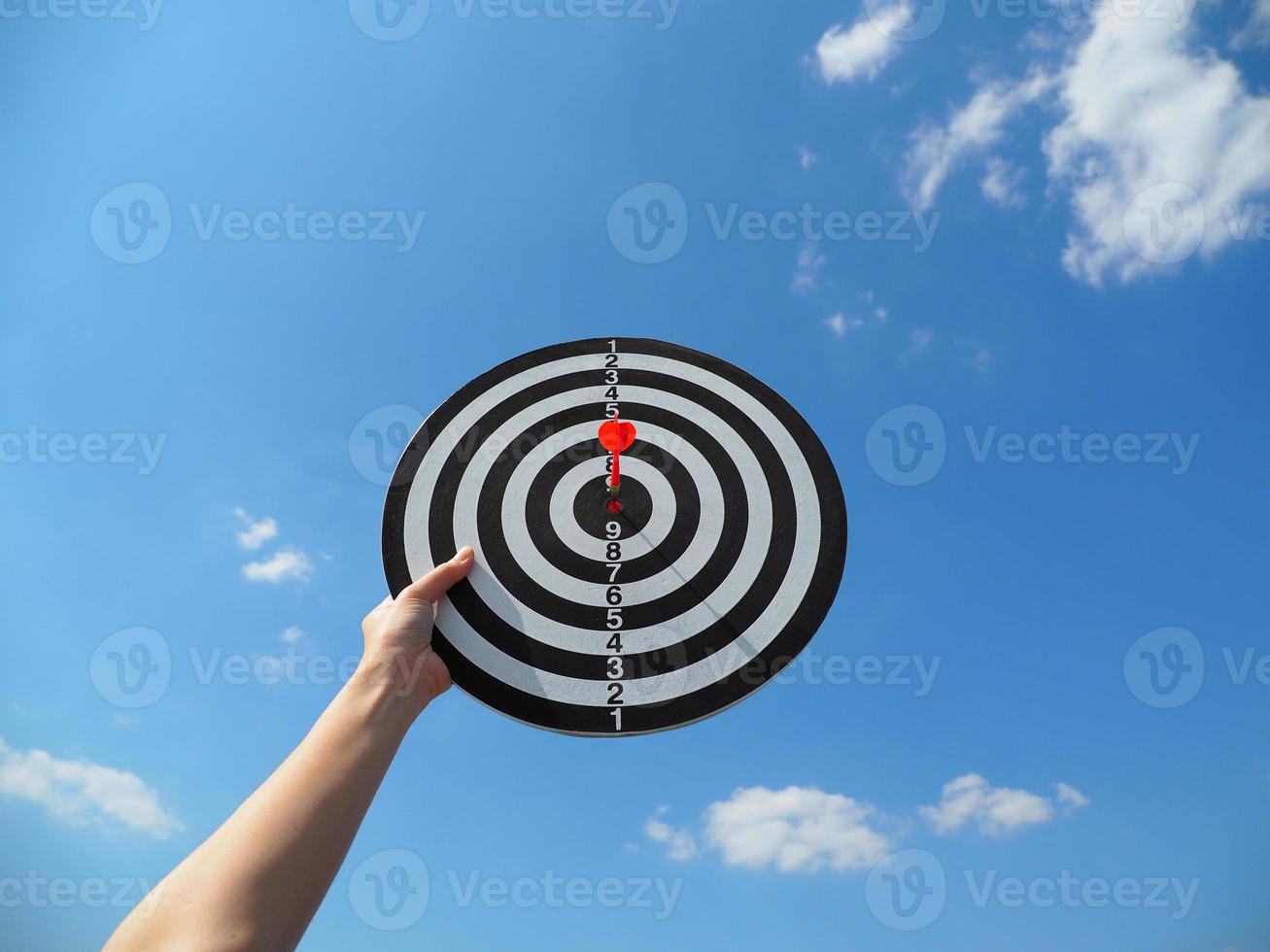 Hands of a young woman holding a goal board up to the sky. Success in business concept. photo