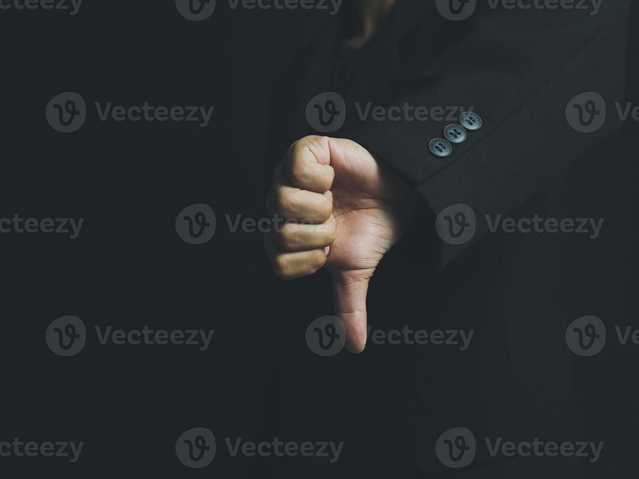 Businessman with thumb down or pointing thumb down The work was not successful. Poor team work photo