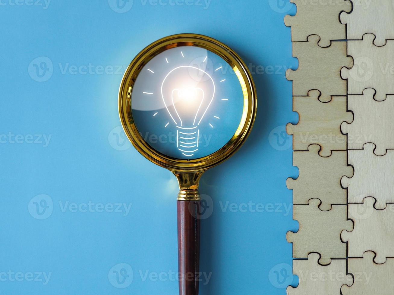 a light bulb on a magnifying glass an extended concept Creation of new opportunities, new ideas, on a blue background photo