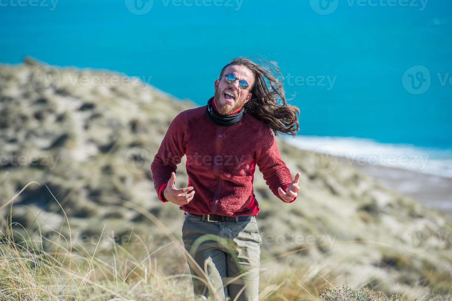 hombre de pelo largo corriendo por los acantilados foto
