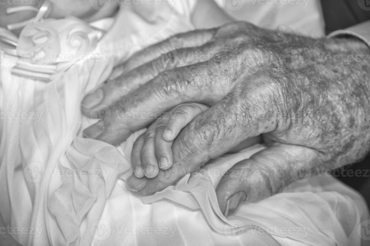 old retired man hands holding newborn infant one photo